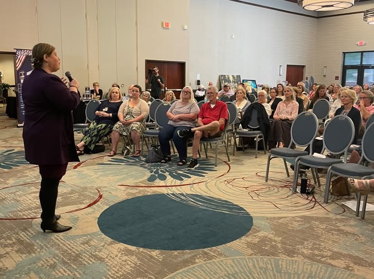 Orly Amor speaking to a full audience of coaches and business owners